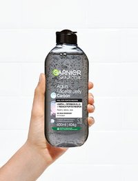 Agua micelar carbón botella mano sujetando