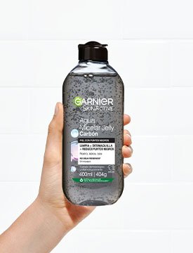 Agua micelar carbón botella mano sujetando